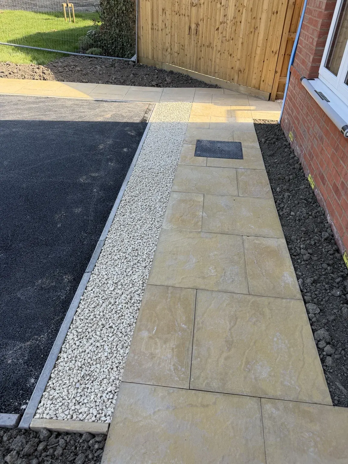 Finished paving, gravel strip and drain cover detail in Swadlincote